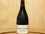une bouteille de vin posée sur un tonneau en bois
