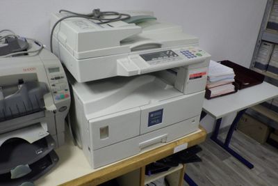 une pile d'imprimantes posée sur une table dans une pièce