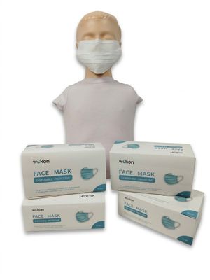 une personne portant un masque à côté de trois boîtes de masques