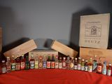 Plusieurs bouteilles d'alcool sont alignées sur une nappe rouge