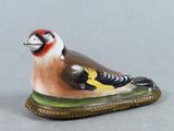 a figurine of a bird sitting on the ground