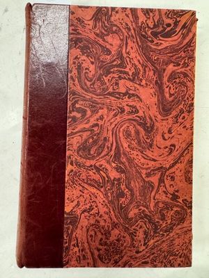 un vieux livre à la couverture rouge posé sur une table