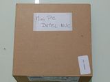 une boîte en carton sur laquelle est collé un autocollant indiquant « I'm PE Intel NUC »