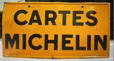 un panneau jaune sur lequel est inscrit « Cartes Michelin »