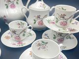 many cups and saucers that are sitting on a table