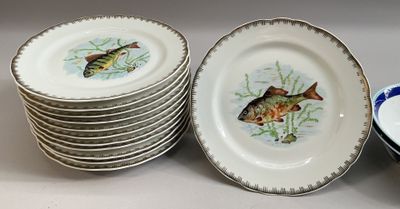 de nombreuses assiettes ornées de poissons, posées sur une table