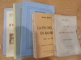 Plusieurs livres sont empilés sur une table en bois ; l'un est bleu et l'autre est jaune.