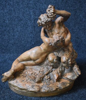 statue of a man and a woman on a rock with a flower in his hand