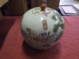 a vase with a lid sitting on a table