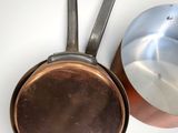 pots and pans sitting next to each other on a white surface