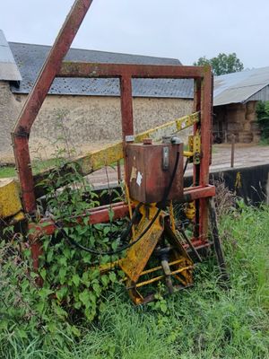 un tracteur qui est garé dans l'herbe près d'un bâtiment