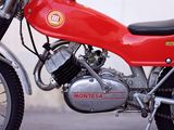 a red motorcycle parked in front of a white wall