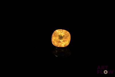 a close up of a yellow diamond on a black surface