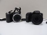 two cameras sitting next to each other on a table