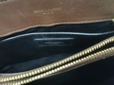 the inside of a brown purse with a gold zipper