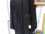 une robe noire accrochée au mur à côté d'un tableau