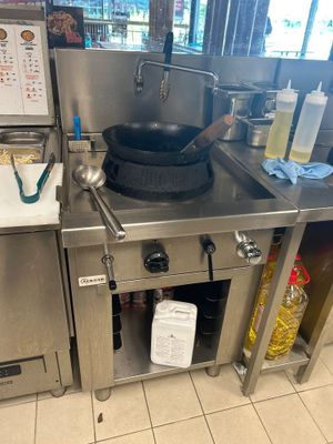une cuisinière sur laquelle est posée une marmite dans une cuisine