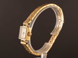 a close up of a watch on a stand with a black background