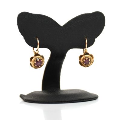 gros plan d'une paire de boucles d'oreilles sur un support