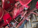 a red tractor that is parked in a garage