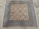 an old rug with a diamond design on it on the ground
