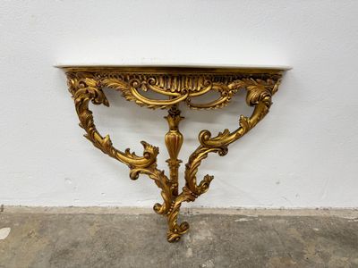 an image of a gold console table with a marble top