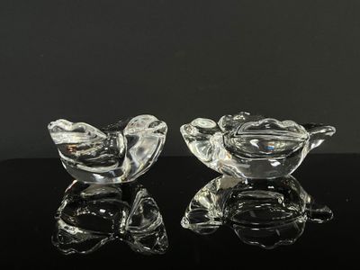 deux oiseaux en verre transparent posés sur une table noire