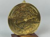 an image of a gold clock on a wooden stand