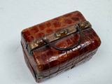 a small brown suitcase sitting on a white surface