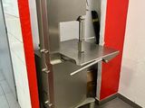 un évier en acier inoxydable dans le coin d'une toilette publique