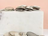 marble block with a pile of coins sitting on top of it