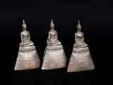 three silver buddha figurines sitting on top of each other
