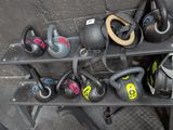 a rack of kettle weights and other gym equipment on the floor