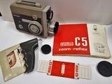 un appareil photo et un livre posés sur une table, à côté d'autres objets