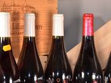 several bottles of wine are lined up in a row in front of a wooden box