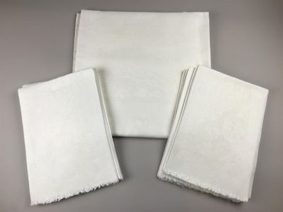 three white napkins sitting on top of each other on a table
