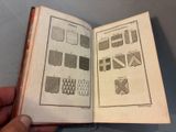 someone is holding an open book with a bunch of drawings on it