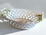 a white basket with flowers on it sitting on a table