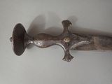 a very old sword that is laying on a table