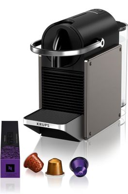 un gros plan d'une machine à café avec une tasse de café à côté