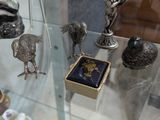 une vitrine en verre remplie de figurines en argent et d'autres objets