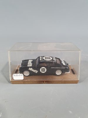 a small black car in a clear box on a table