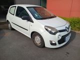 une photo d'une petite voiture blanche garée devant un immeuble