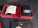 two boxes with a clock and a book on a table