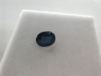 un saphir bleu posé sur une surface blanche