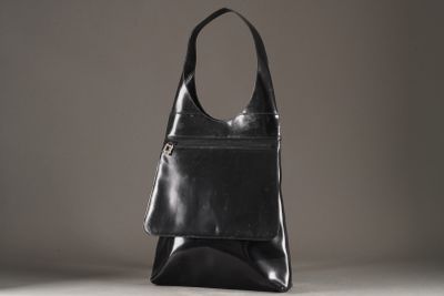 un sac en cuir noir posé sur une table blanche