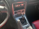 the interior of a car with red leather seats and dashboard controls