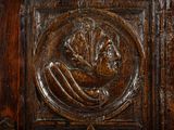 a wooden door with a carving of a woman holding a fan
