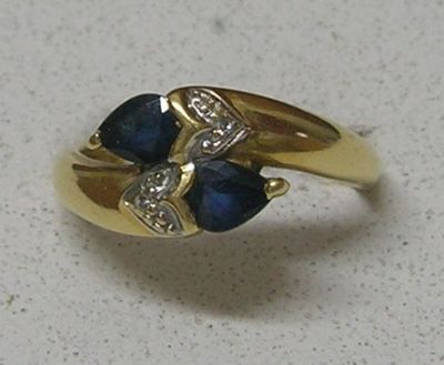 une photo d'une bague en or sertie de deux saphirs bleus et de diamants