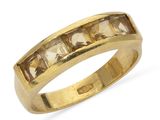 un gros plan d'une bague en or jaune sertie de pierres taillées en carré